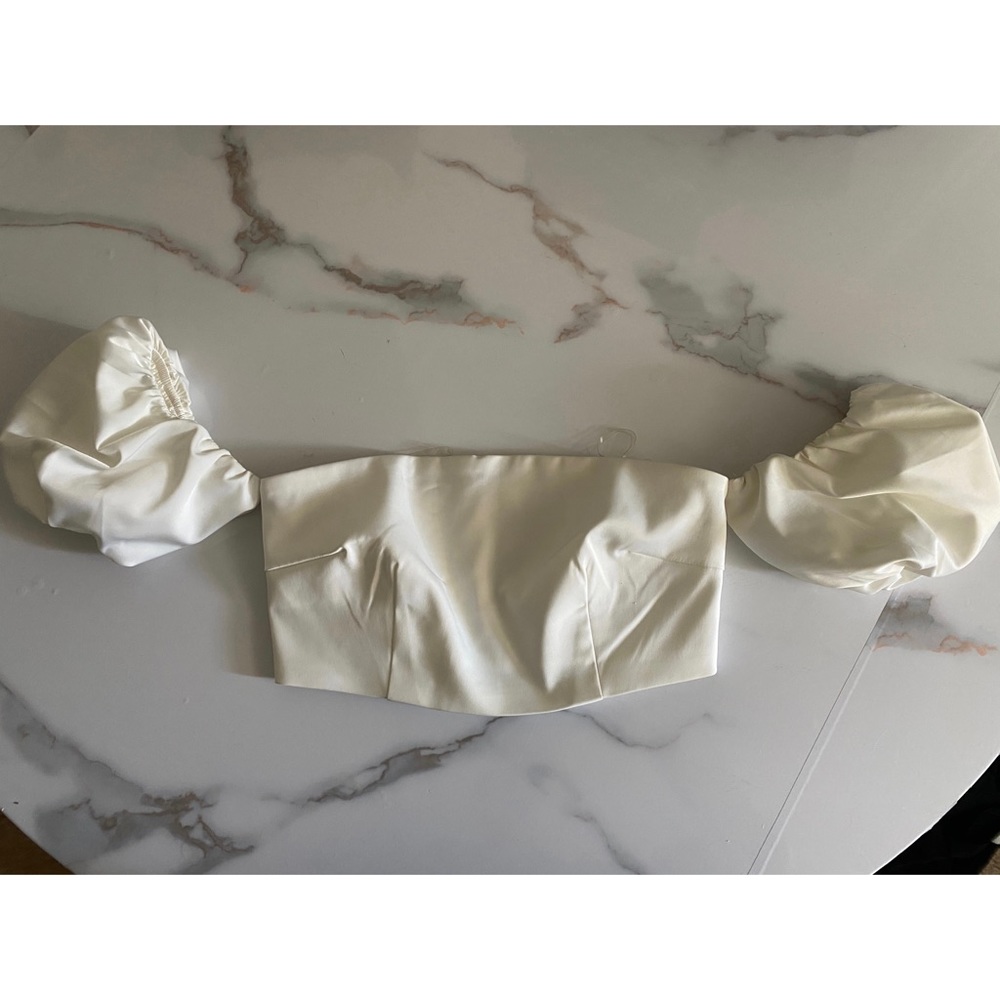 Meshki strapless top with puff sleeves.